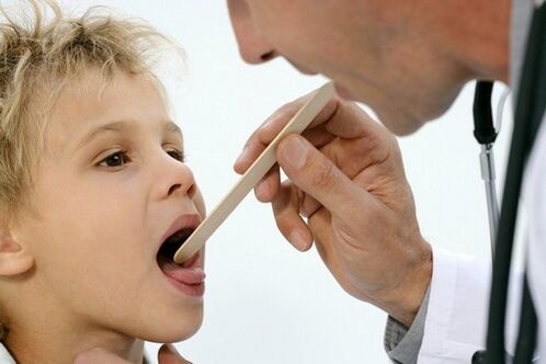 gydytojas apžiūri psoriaze sergančio vaiko gerklę