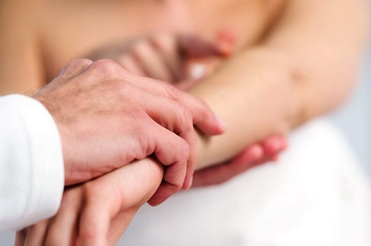Dermatologas tiria psoriaze sergantį pacientą